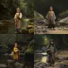 A little girl in ancient attire stood by the stream