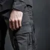 照片，城市军事，技术材料，文本上的面料小点标签灰色理论，小点，设计极简，面料为深灰色，具有微妙的纹理变化，以低角度设置以捕捉裤子形式和细节，f/5.6专注于裤子工艺，纯灰色背景，工作室灯光设置