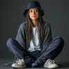捕捉模特，穿着长袖羊毛衫搭配白色T恤的女人，深蓝色洗涤货物慢跑裤，滑板鞋，带有小细节的黑色水桶帽，Canon EOS-1D，f/5.6，灰色背景，工作室灯光设置