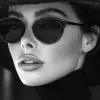 a woman wearing black sunglasses and a hat, in the style of black and white imagery, vray tracing, tamron sp 70-200mm f/2.8 di vc usd g2, bold fashion photography, luminous shadowing, close-up, crisp 