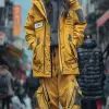 摄影，28岁女性，职业模特，自然姿势，穿着小文本标志，衣服染色战术宽松卡车司机夹克搭配黑色连帽衫，慢跑裤，黄色Yeezy boost 350，在主干道的街道人行横道上，佳能EOS-1D Mark III，将捕捉上衣和裤子的形式和细节，大量路人，长时间曝光，真实感，真实感光--ar 9：16 --style raw --styminster 750 --v 6