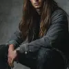 照片，全身，年轻男子职业模特姿势，极简时尚，时尚的nessy长发，凝视，二手相机是佳能EOS R5，配备RF 85毫米F1.2L镜头，纯深灰色环境，现实主义工作室灯光设置，琴键灯，UHD，丰富的细节--ar 9：16 --风格原始
