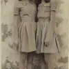 两个女孩在一起，一个穿着连衣裙，另一个穿着衬衫和裙子，1970年至今的风格，深米色和天蓝色，大胆的配色组合，hervé guibert，航海魅力，平面，minolta srt-101 --ar 23：40
