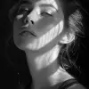 一张带着阴影的女人的黑白照片。，极简主义美的风格，浅青铜色和青铜色，宁静的面孔，锋利的边缘，karencore，高清，对比度阴影，现实主义--ar 3：5 --styminster 750 --v 6.0 --style raw