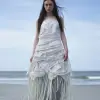 一个穿着白色连衣裙的女人站在海滩上，nagash社论，卫生纸杂志，模糊的蓝色长发，艾略特·科赫克（eliot kohek）的设计，又高又瘦，模糊得令人着迷，鱼皮，褶皱裙子，女妖，光滑的曲线，简·罗森伯格（jane rosenberg），艺术论坛，作者：莉迪亚·菲尔德·埃米特（Lydia Field Emmet）--v 5.2 --ar 3：4
