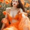 穿着橙色连衣裙的美丽时装模特，坐在橙色花床上，--ar 3：4