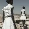 以威廉·克莱因（William Klein）的风格，极其瘦弱、营养不良的非洲黑人在干旱的沙漠风景中穿着白领连衣裙，用单反相机的风格拍摄了彩色摄影。--ar 62：85 --v 6.0