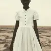 以威廉·克莱因（William Klein）的风格，极其瘦弱、营养不良的非洲黑人在干旱的沙漠风景中穿着白领连衣裙，用单反相机的风格拍摄了彩色摄影。--ar 62：85 --v 6.0