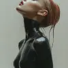 充满激情的运动芭蕾舞演员以闪亮的黑色衣服展示，大胆的家庭亲密感和猫女风格，半身视图，白色背景，彩色摄影作者：marta bevacqua --ar 4：5 --s 1000