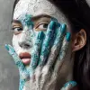 这是一位迷人的女人的肖像，她的脸上和脖子上涂着白色的油漆，蓝色的双手从彩绘的皮肤上伸出。她的黑发松散地披在肩上。背景色应该是灰色，以便与她的五官形成良好对比。彼得·林德伯格为《Vogue》杂志拍摄。--ar 51：64 --s 1000 --c 100 --w 1000