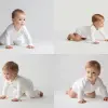 一名欧美婴儿 wearing a white onesie is crawling on a plain white background, with a minimalist and clean aesthetic. The baby's posture is focused, and the simple setting highlights the innocence and tender 