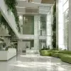 综合医院大楼，宽敞大厅和绿色植物点缀，洁白与淡绿色调，现代医疗风格，自动门和清晰标识细节，明亮灯光和窗外自然光混合，环境干净明亮，建筑设计效果图     --ar 4:3